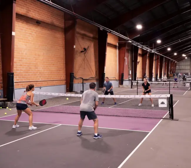 Casual open play session — mixed group, relaxed energy, people meeting each other on court. 